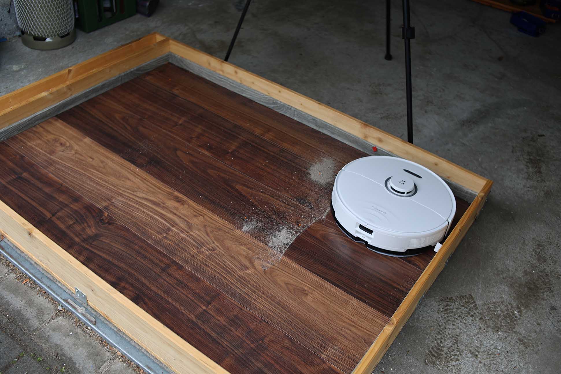 Roborock S8 Pro Ultra убирает песок в тесте на мощность всасывания на ламинате.